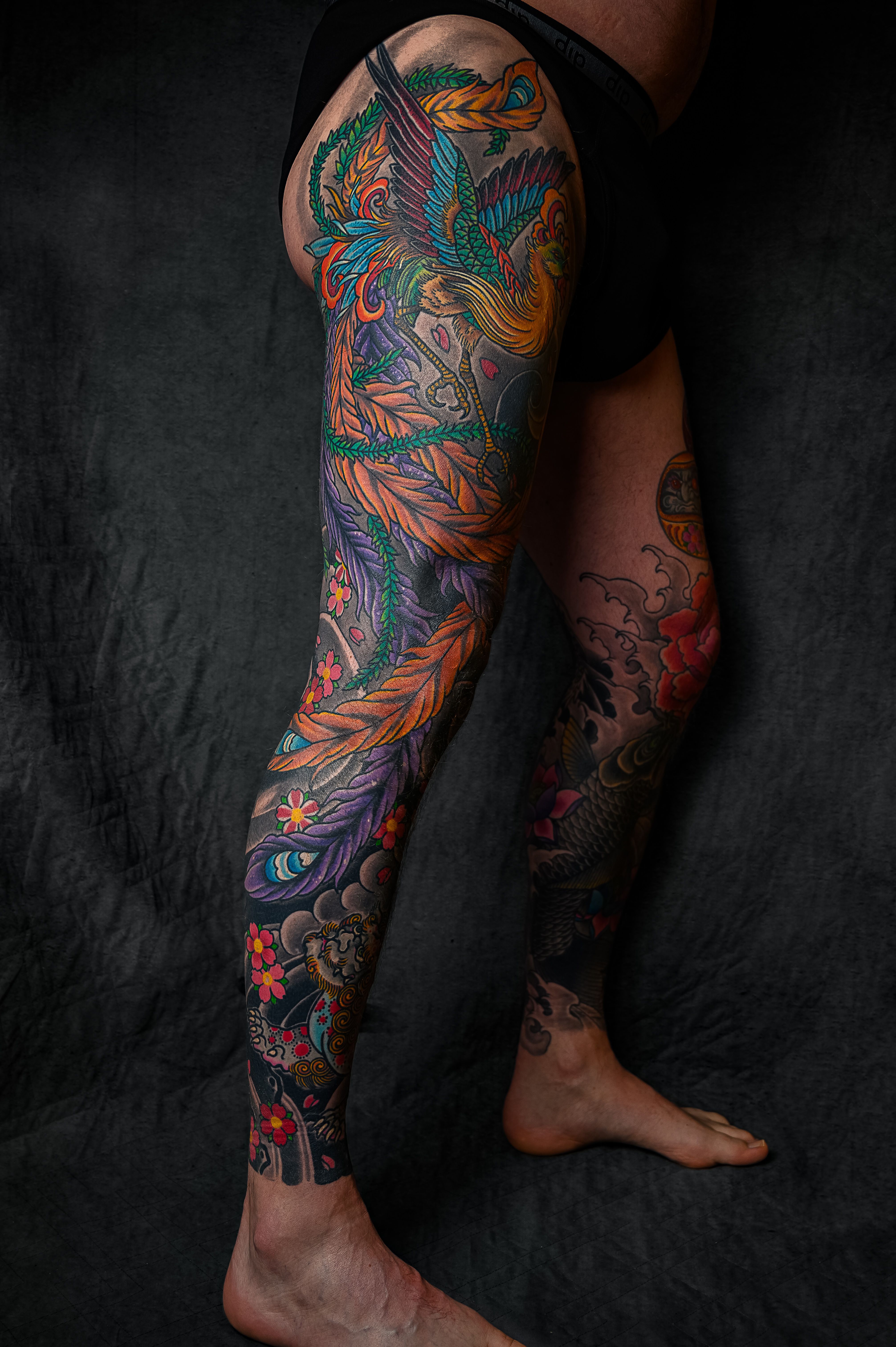 Manga completa de perna com tatuagem japonesa de Hō-ō em penas coloridas vermelhas e douradas